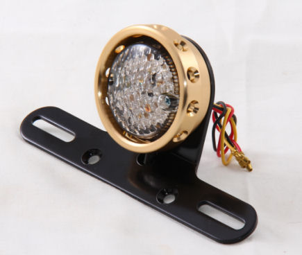 LED tail light with drilled brass lens bezel.